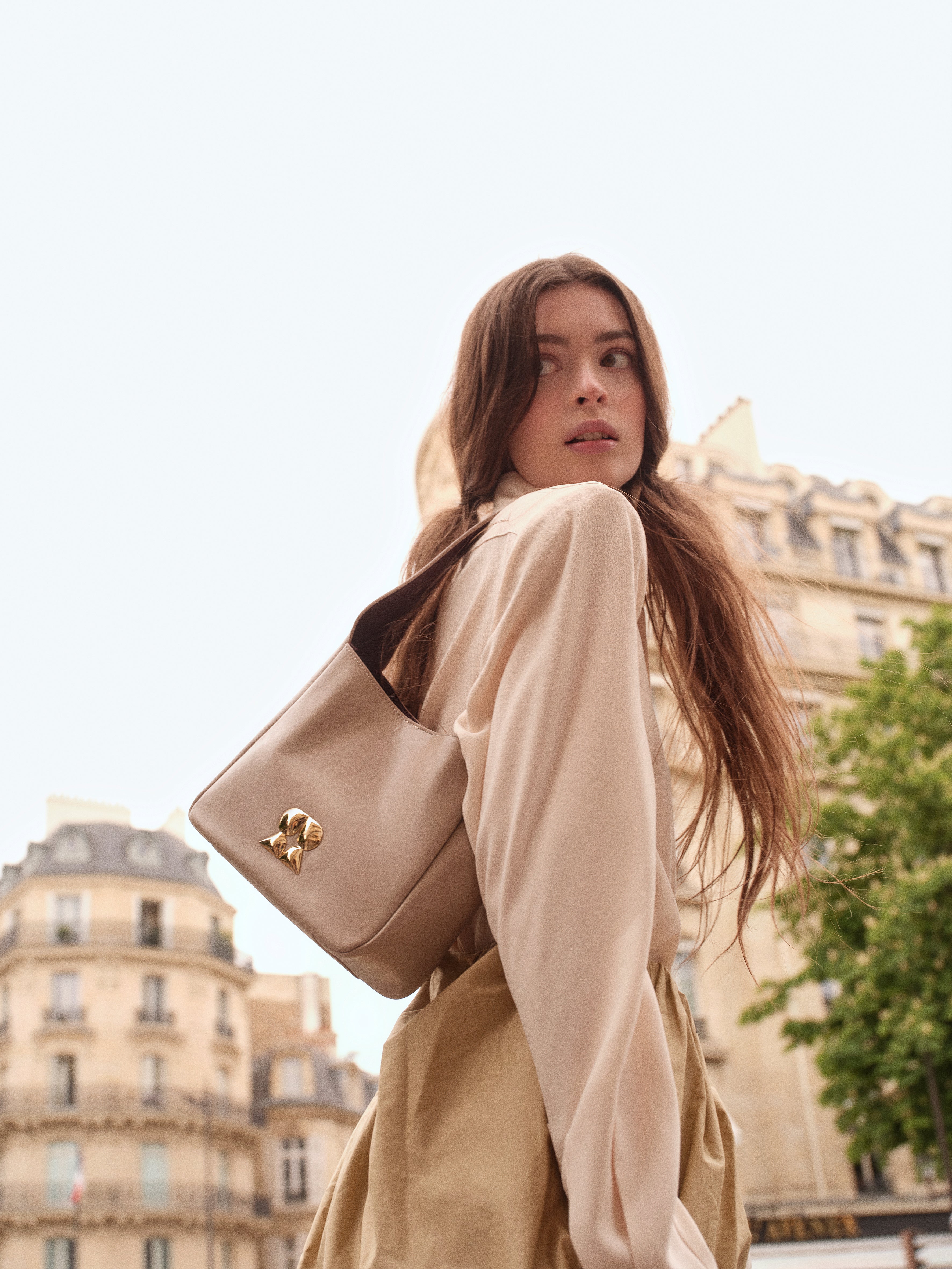Model wearing the Rilu Camellia beige leather shoulder bag in Paris