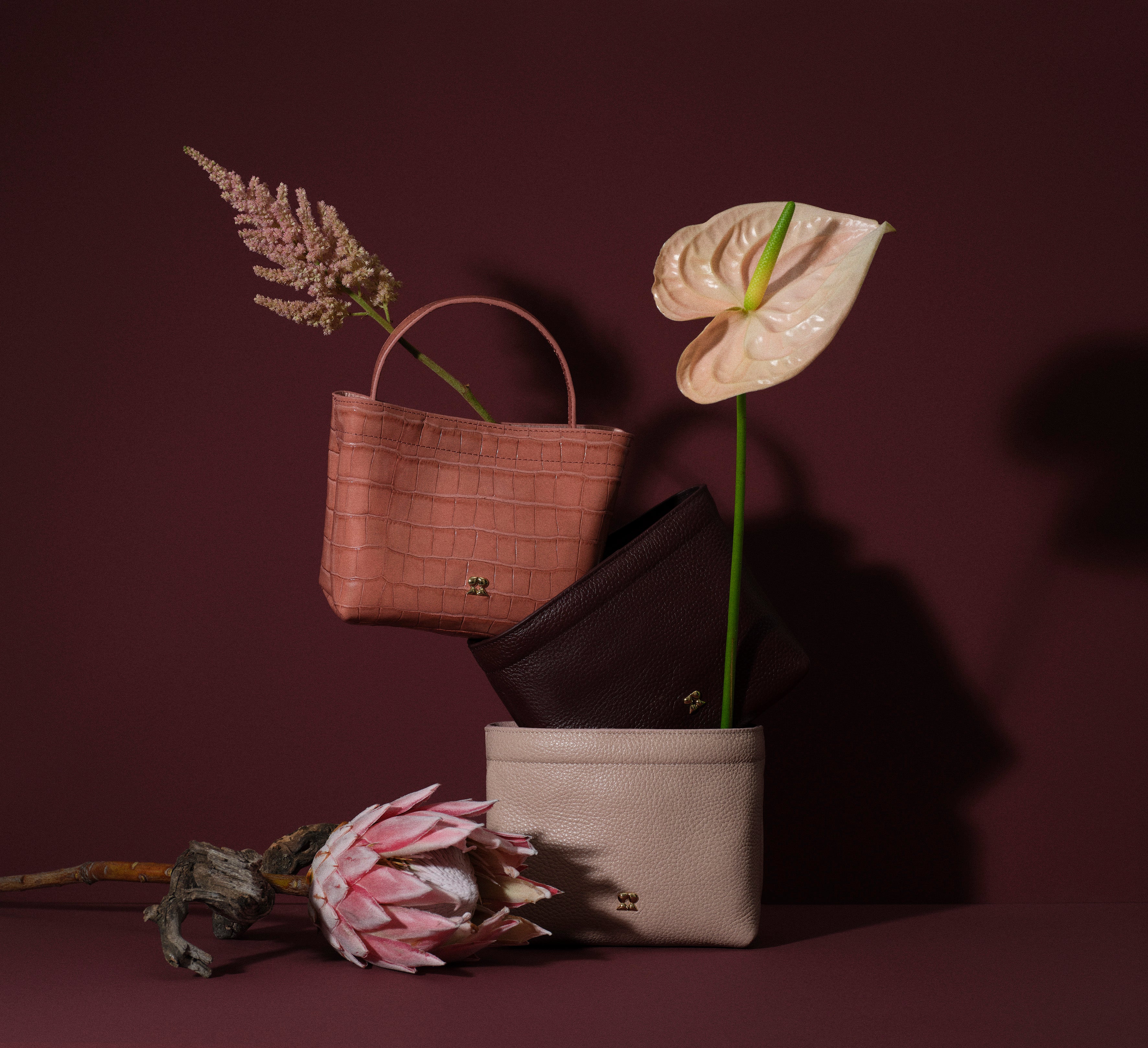 Rilu loulou leather mini bags in pink, brown and beige styled in a floral still-life composition